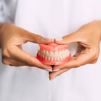 Lady presents viewer with dentures