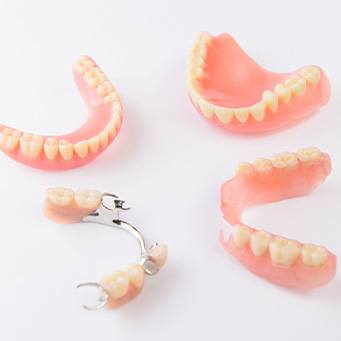 Full and partial dentures arranged in circle on white surface
