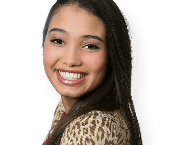 Young woman in leopard print blouse smiling brightly in Whitinsville