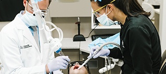 Dentist and team member treating dental patient