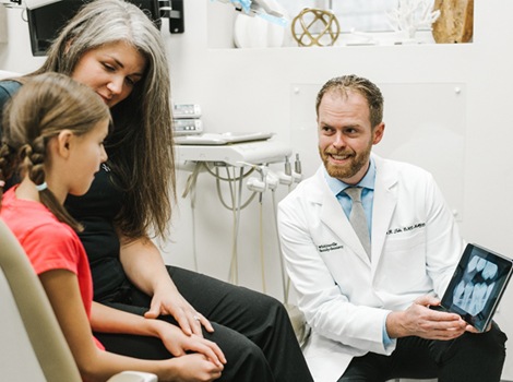 Dr. Tubo consulting with young patient and her mother