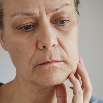 a woman touching her cheek 