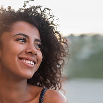 a smiling woman standing outside