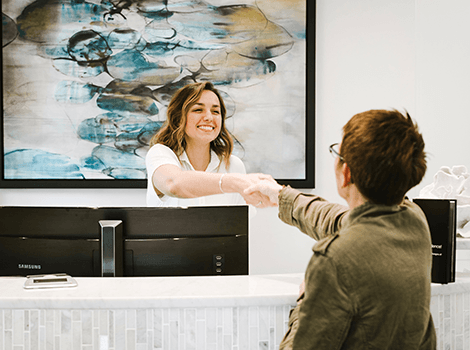 Patient shaking hands with team member after Invisalign in Whitinsville