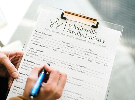 person filling out paperwork for Whitinsville Family Dentistry 