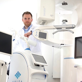 dentist standing next to a dental machine