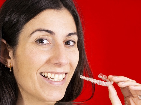 Woman holding SureSmile® clear aligner