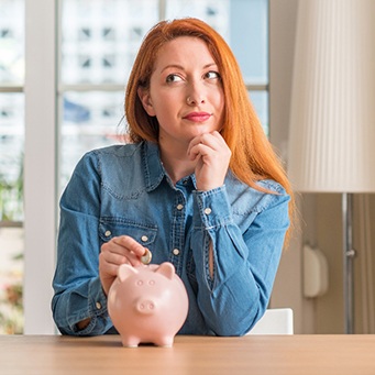 Woman putting coin in a piggy bank