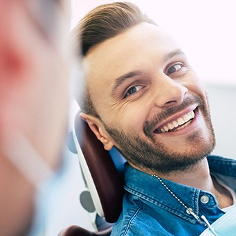 Man smiling at dentist while sitting in treatment chair
