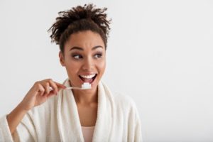 Woman brushing her teeth in the mirror