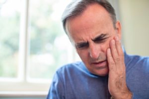 Man in pain who needs an emergency dentist in Whitinsville 