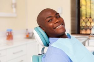 Man smiling in chair at visit with dentist in Whitinsville