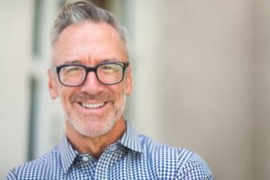 Man smiling with collared shirt and dental implants