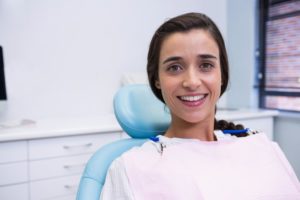 Woman smiling in dental chair with dental implants in Whitinsville