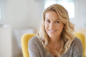 Woman smiling with veneers while looking at camera