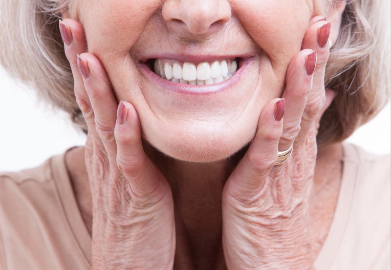 woman smiling after getting dentures in Whitinsville