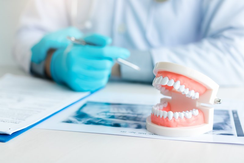 Dentist with a set of dentures lying on a desk