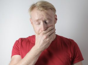 Man with hand over his mouth from dental pain