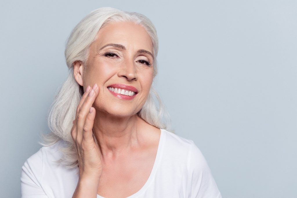 patient smiling after having ill-fitting dentures fixed