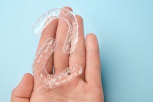 Two clear aligners on person's hand
