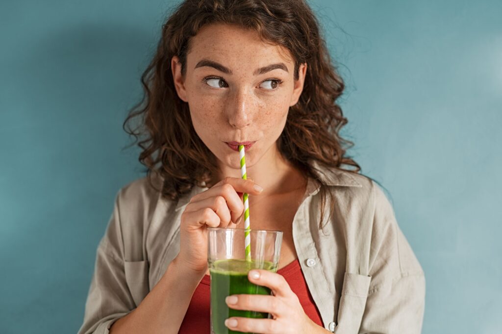 Woman with curly hair drinking through straw