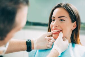 Dentist examining patient’s smile.